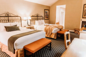 A cozy room at the Oregon Garden Resort with two queen beds and a gas fireplace